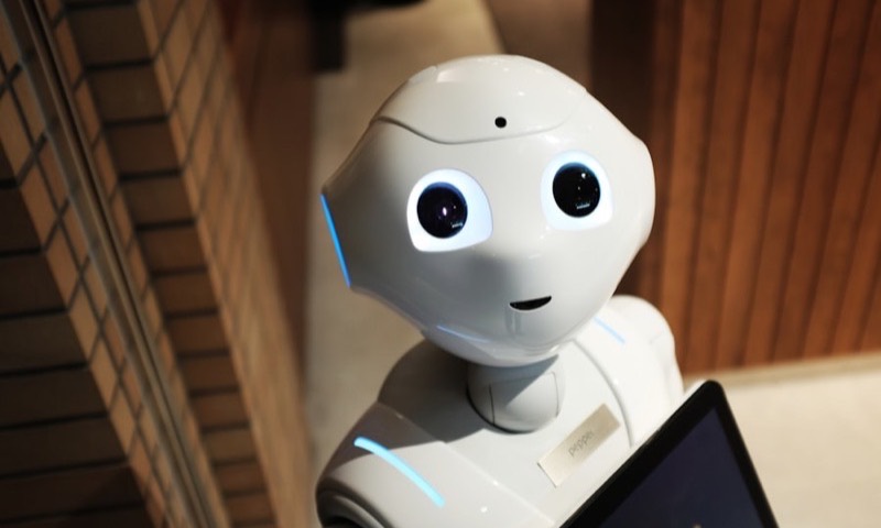 A friendly white humanoid robot looking at the camera
