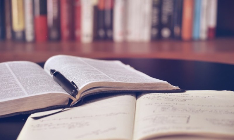 Open reference books with handwritten notes