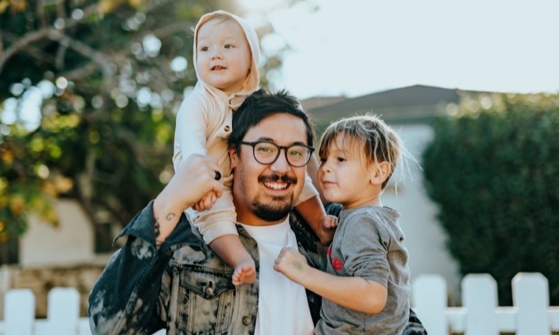 A father laughing with his two young children