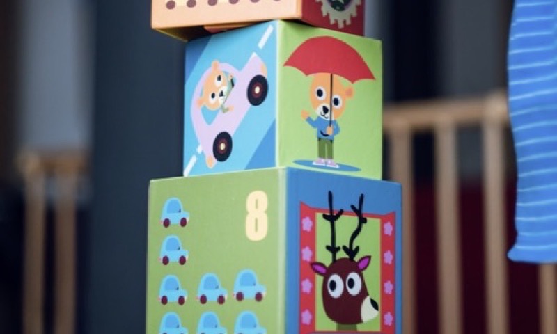 A toddler stacking colourful number blocks